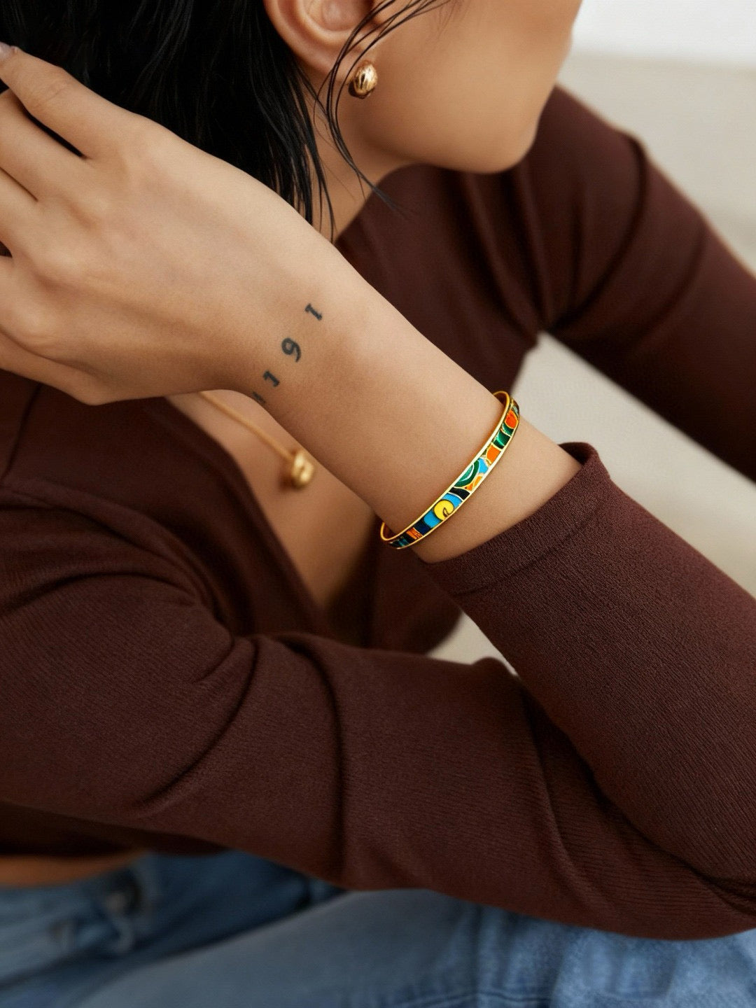 Person wearing a colorful bracelet on a plain background