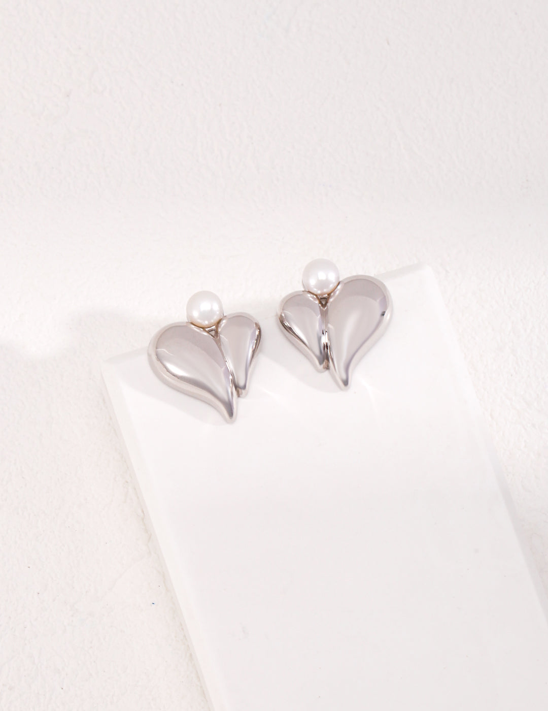 Dare To Sparkle - Elegant 3D structural heart-shaped stud earrings featuring a high-polished metallic fluid frame centering a luminous white round shell pearl in silver