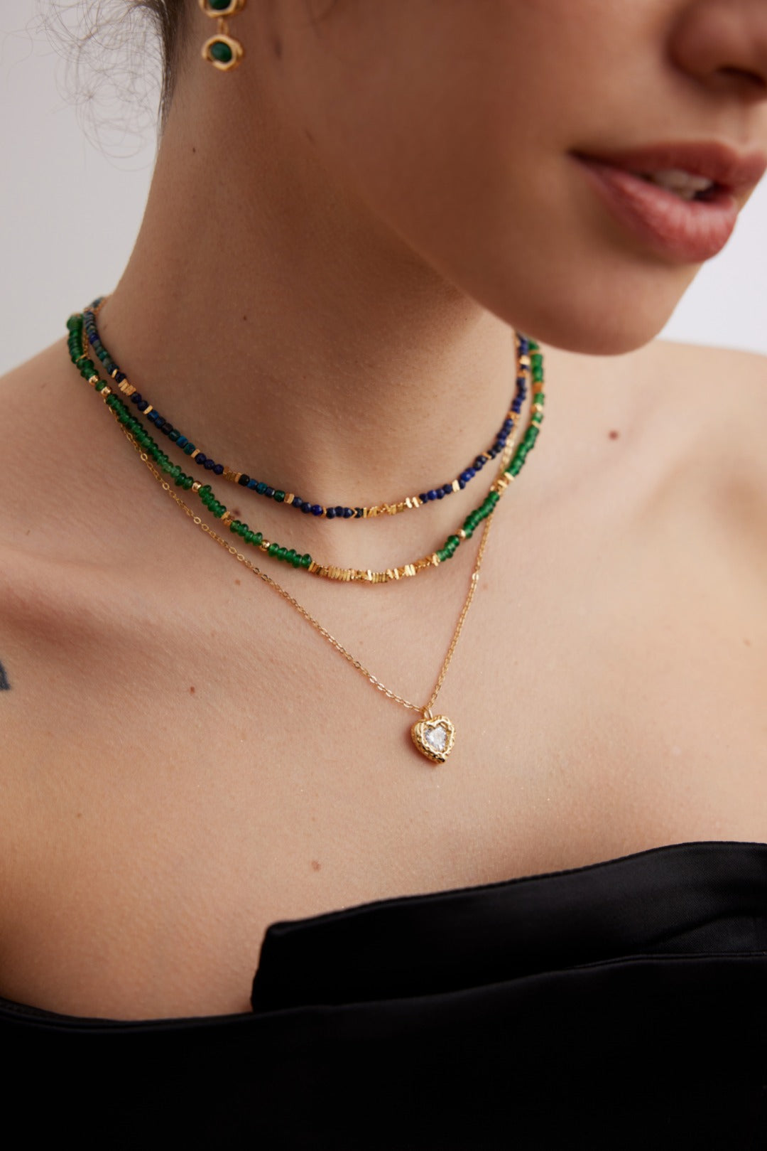 Close-up of a person wearing romantic 3D puffy heart pendant necklace featuring high-polished 18k gold plating inlaid with brilliant white cz