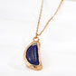 Closed look of vintage gold arc pendant necklace with natural blue lapis lazuli stone and organic textured molten framing