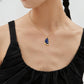 A model wearing vintage gold arc pendant necklace with natural blue lapis lazuli stone and organic textured molten framing