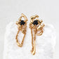Dare To Sparkle - Avant-garde asymmetric gold molten lava earrings featuring natural black onyx beads with flowing liquid chain tassels