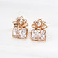 Gold earrings with clear gemstones on a white background