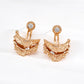 Pair of gold earrings with intricate designs on a white background