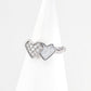 Silver ring with heart-shaped designs on a white background