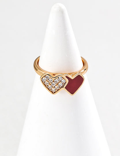 Gold ring with heart design on a white stand
