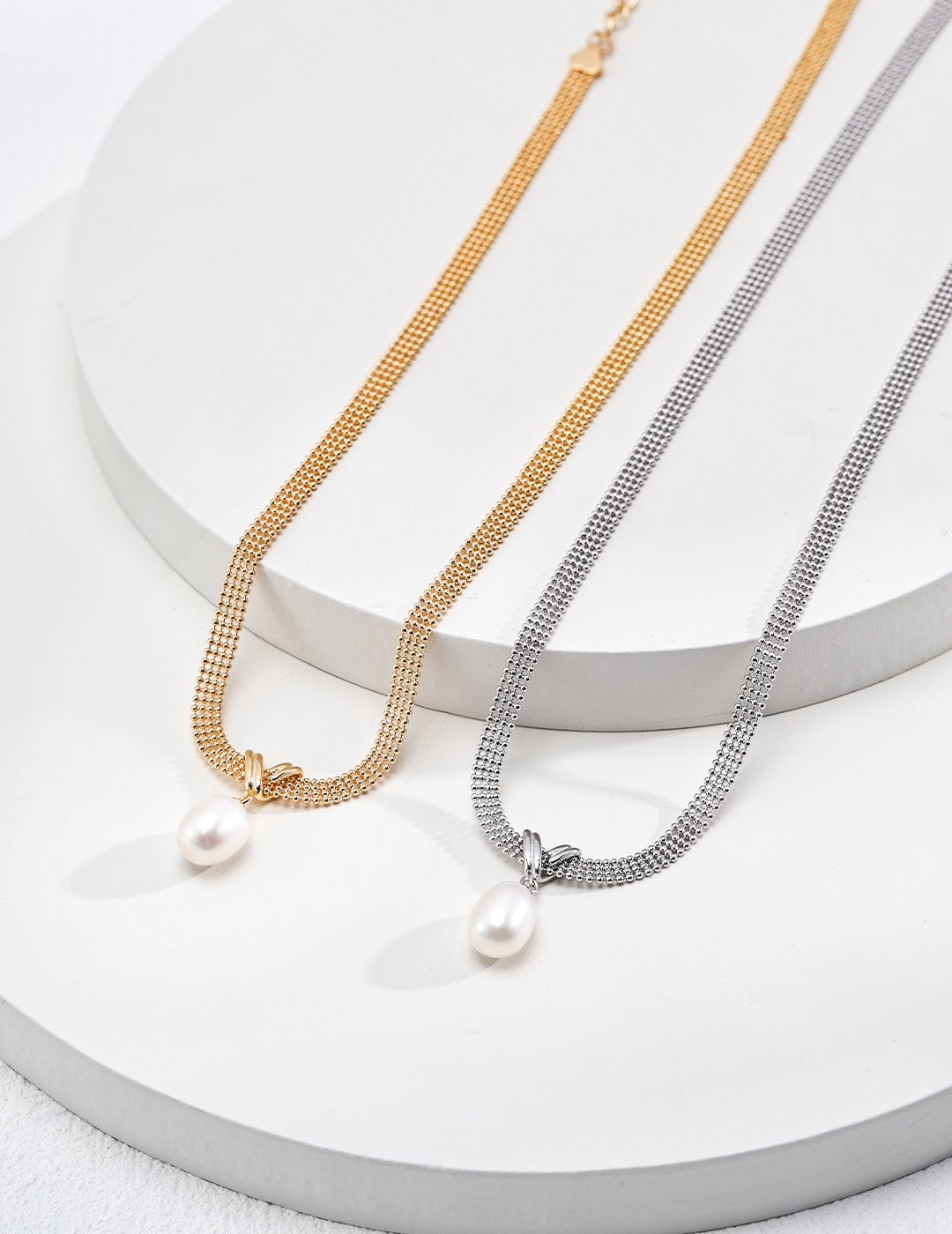 Dare To Sparkle - Statement multi-strand flat mesh snake chain necklaces with a central crossed knot loop and a dangling teardrop natural pearl in silver and gold