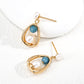 Dare To Sparkle - Vintage lantern-inspired gold earrings featuring a natural white pearl candle motif and a dangling blue gemstone bead