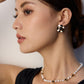 A model wearing regal vintage gold statement earrings featuring large wavy metallic discs centering a polished natural black onyx stone