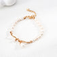 Dare To Sparkle - Elegant retro gold bracelet with a central fluid intertwined vine knot holding natural freshwater pearl charms on a lustrous pearl strand