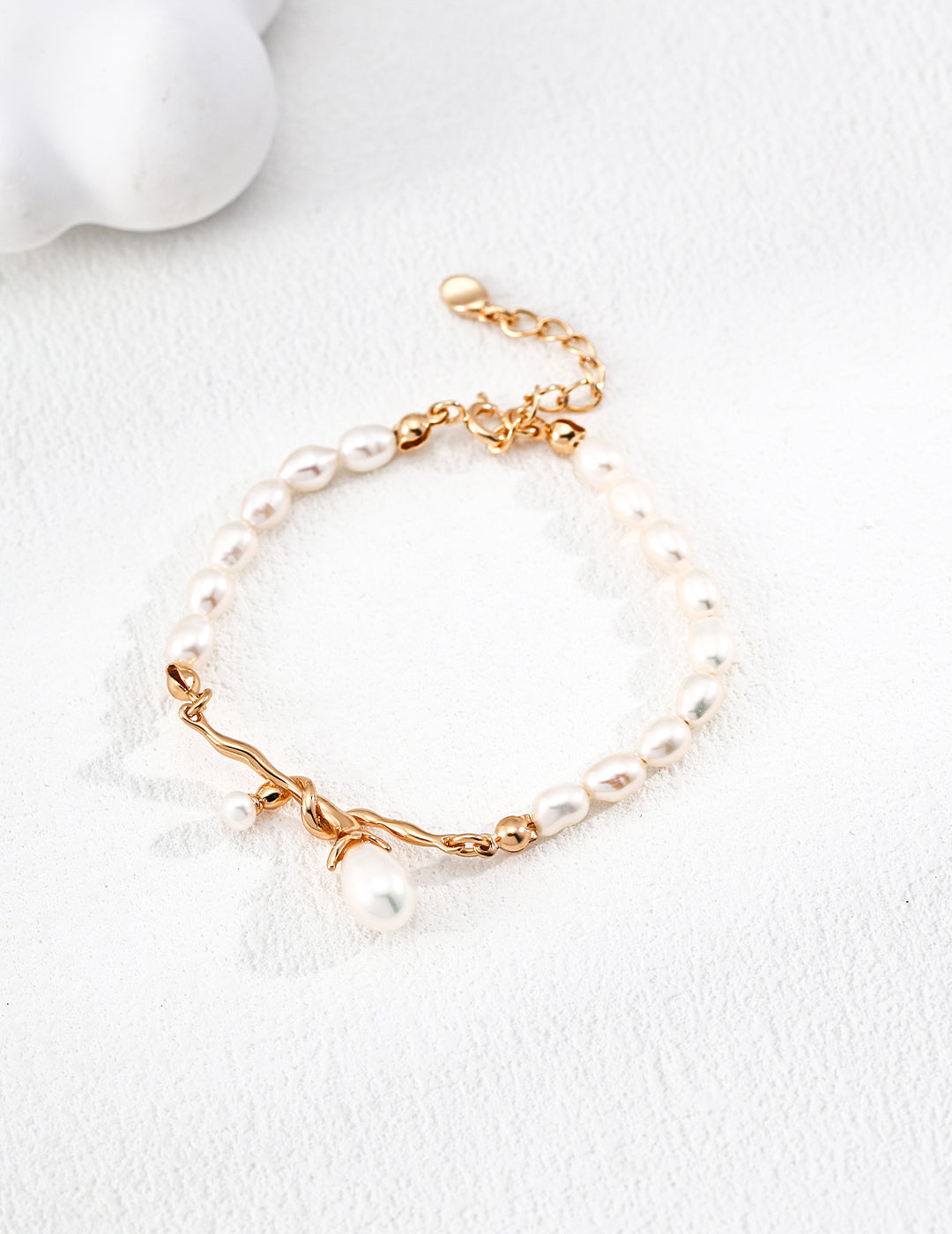 Dare To Sparkle - Elegant retro gold bracelet with a central fluid intertwined vine knot holding natural freshwater pearl charms on a lustrous pearl strand
