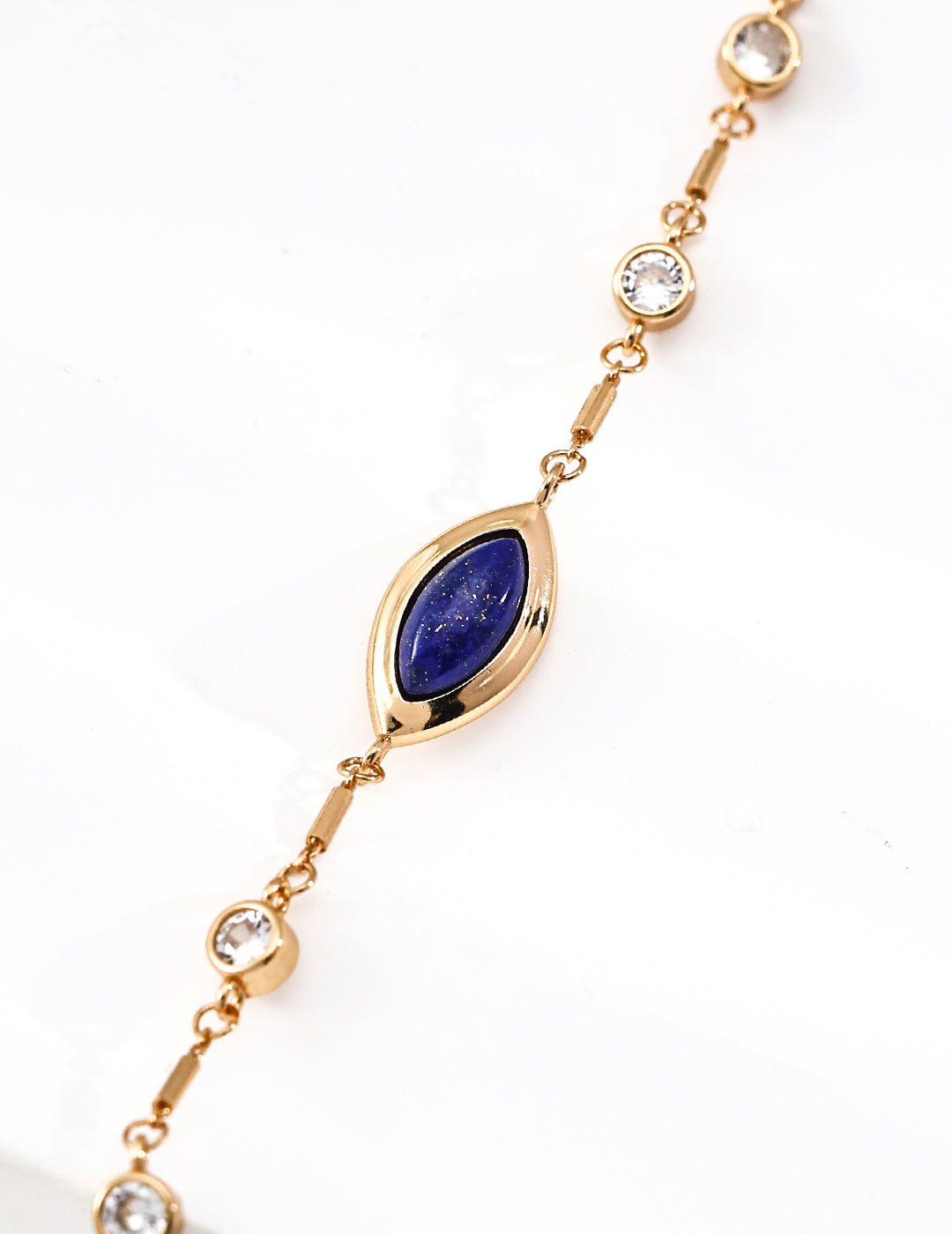 Close-up look of the elegant vintage gold chain bracelet featuring a central marquise natural deep blue lapis lazuli stone and bezel-set round cz crystals