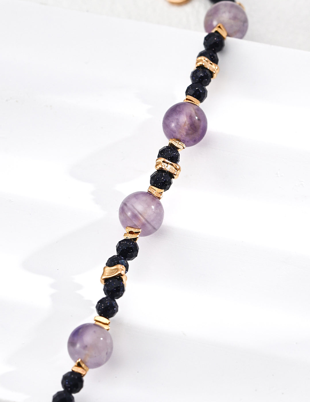 Necklace with purple and dark blue beads on a white background