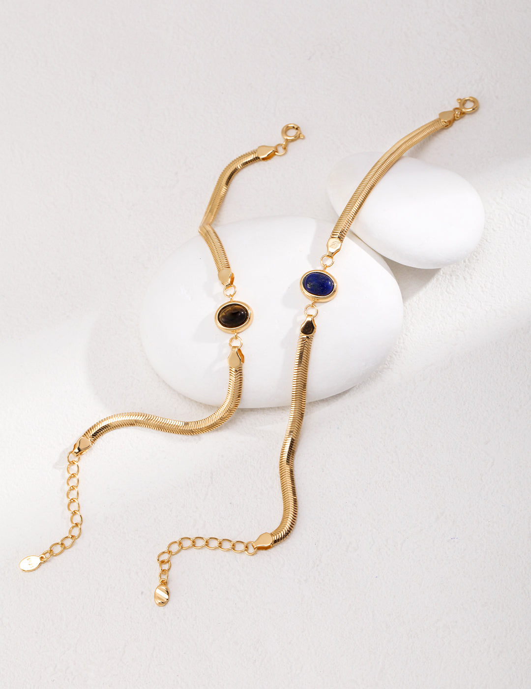 Dare To Sparkle - Sleek 18k gold plated flat herringbone snake chain bracelets with a central bezel-set oval natural lapis lazuli and tiger's eye stone