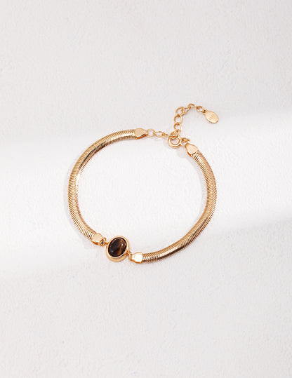 Dare To Sparkle - Sleek 18k gold plated flat herringbone snake chain bracelets with a central bezel-set oval natural tiger's eye stone