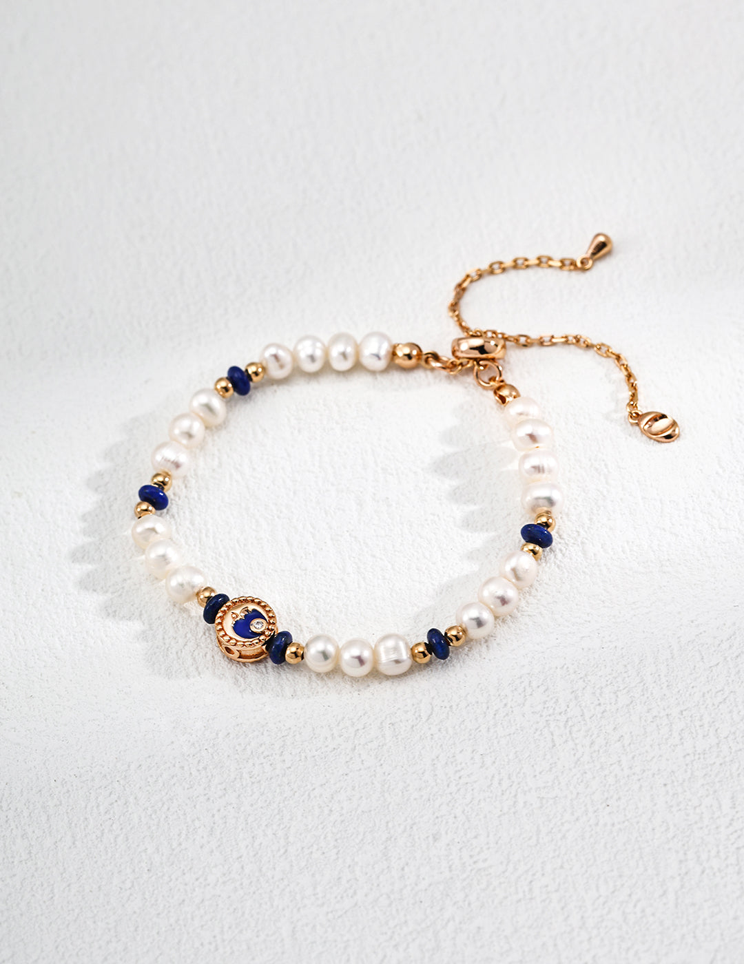 Dare To Sparkle - Luminous natural freshwater pearl strand bracelet with dark blue lapis lazuli accents and a central gold celestial crescent moon charm with a cz crystal