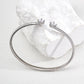 Contemporary minimalist open-band cuff bracelet in silver finishes featuring radiant prong-set cz gems flanking both open ends