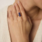 A model wearing an antique-inspired statement open adjustable ring featuring a central round natural deep blue lapis lazuli stone within a geometric gold bezel
