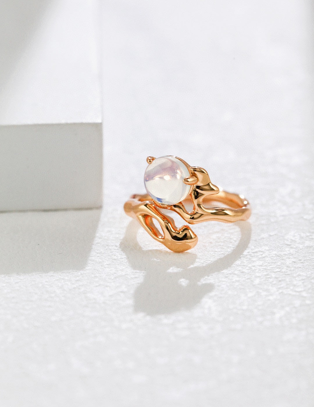 Gold ring with a central gemstone on a white background