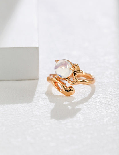 Gold ring with a central gemstone on a white background