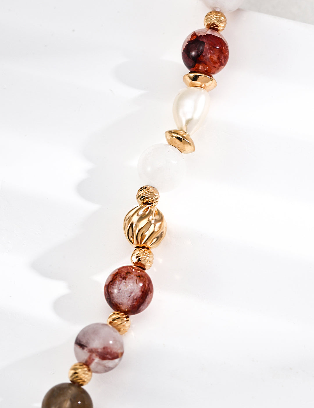 Bracelet with multicolored beads and gold accents on a white background