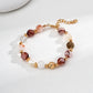 Dare To Sparkle - Luxury strand bracelet featuring rich red hematoid quartz beads, clear crystals, glowing white pearls, and a central textured twisted gold ball