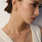 A model wearing a versatile high-polished sterling silver faceted bead chains shown with and without a detachable starburst engraved round coin pendant in gold