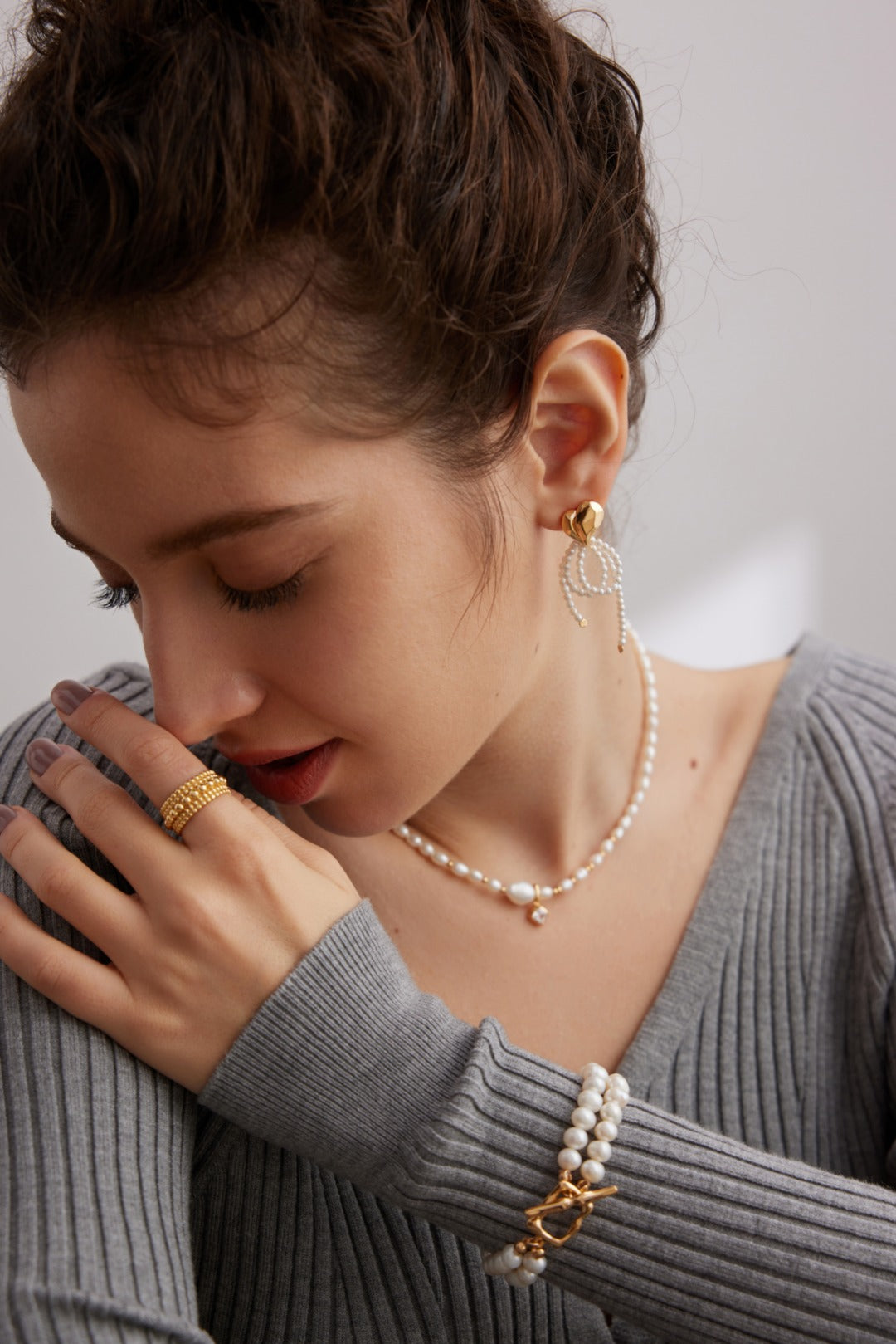 A model wearing 3D Heart Bow Pearl Drop Earrings in gold plated sterling silver romantic aesthetic