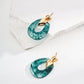 Dare To Sparkle - Art-gallery style drop earrings featuring smoky translucent ink-green moss agate faux resin hoops held by a geometric 18k gold plated claw with pavé cz crystals