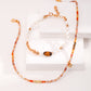 Set of beaded necklace and bracelet on a white surface