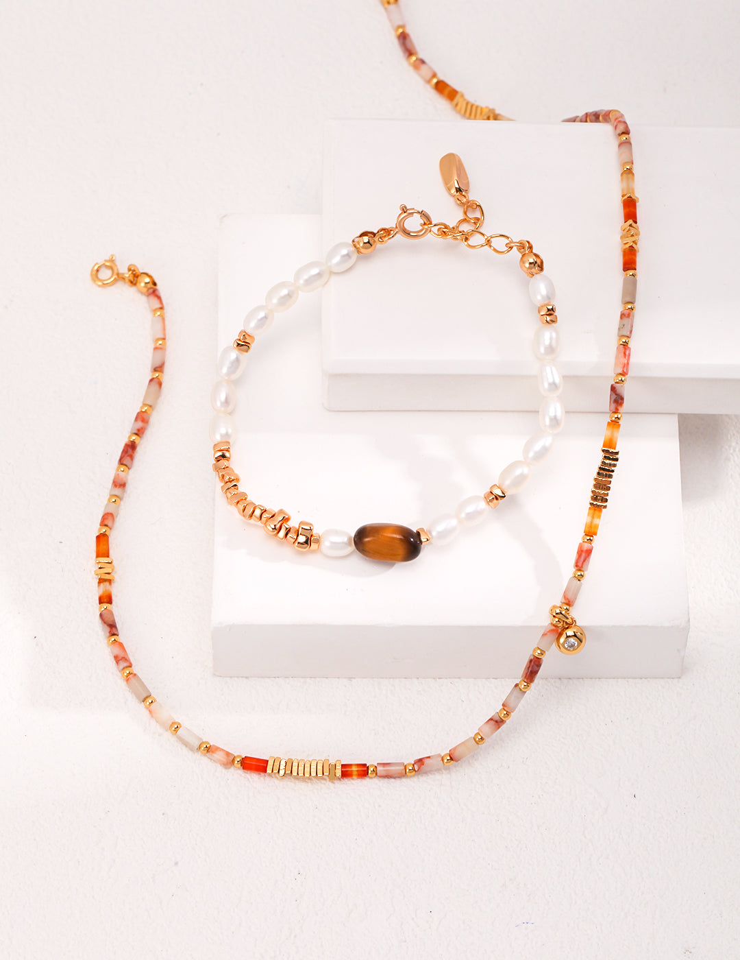 Set of beaded necklace and bracelet on a white surface