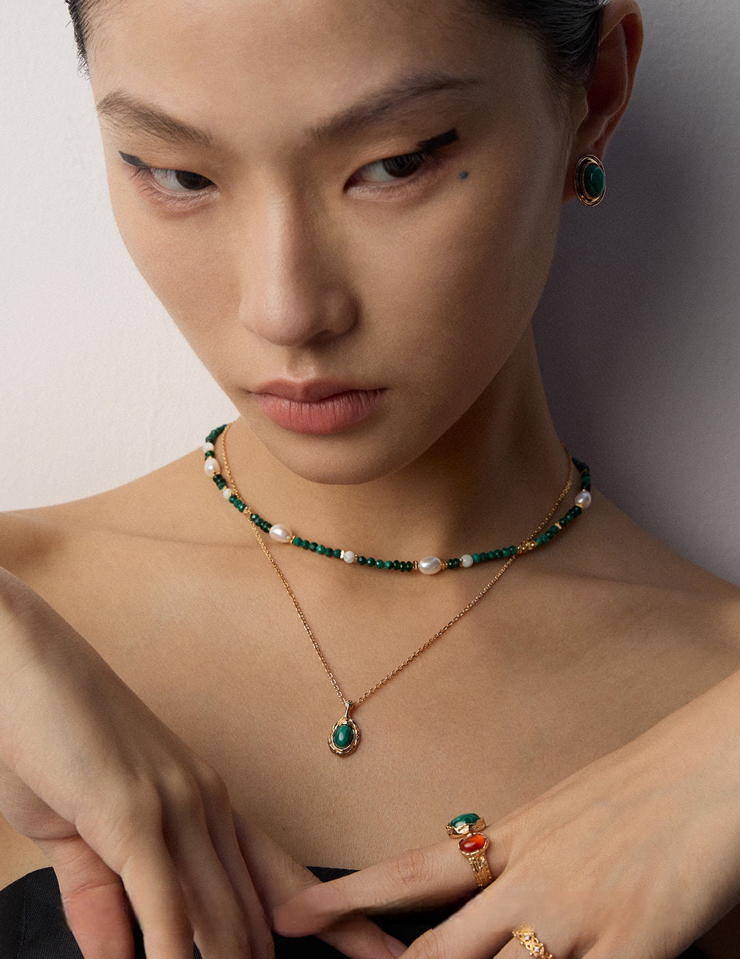 A model wearing an organic molten gold framed natural malachite pendant necklace