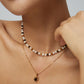 A model wearing an organic molten gold framed round tiger's eye pendant necklace