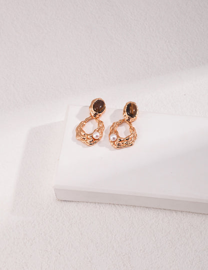 A pari of organic molten gold framed tiger's eye earrings with delicate floating pearl drops