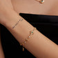 Gold bracelet with gemstones on a wrist against a black background