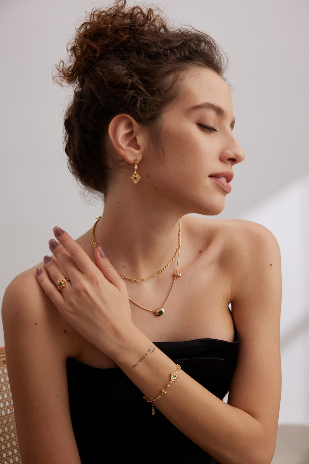 A model wearing French style minimalist jewelry set featuring premium silver prong-set radiant square cubic zirconia pendant necklace, open ring, and stud earrings