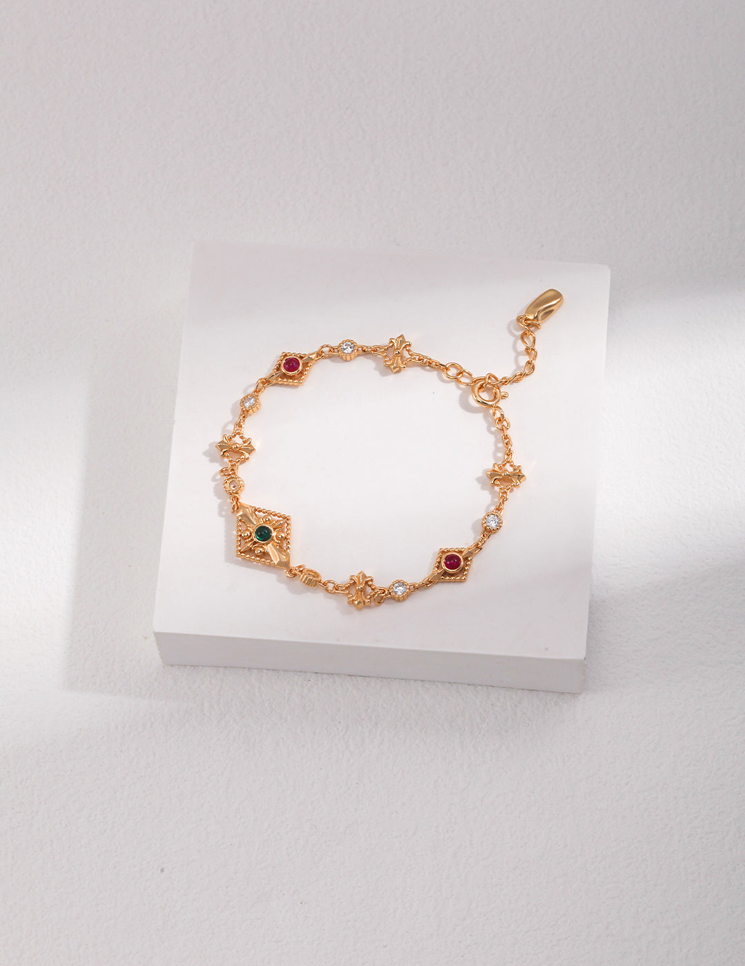 Gold bracelet with gemstones on a white box