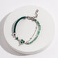Dare To Sparkle - Avant-garde asymmetric split-design bracelet featuring faceted green strawberry quartz beads, fluid molten silver hearts, and a deep green woven silk cord