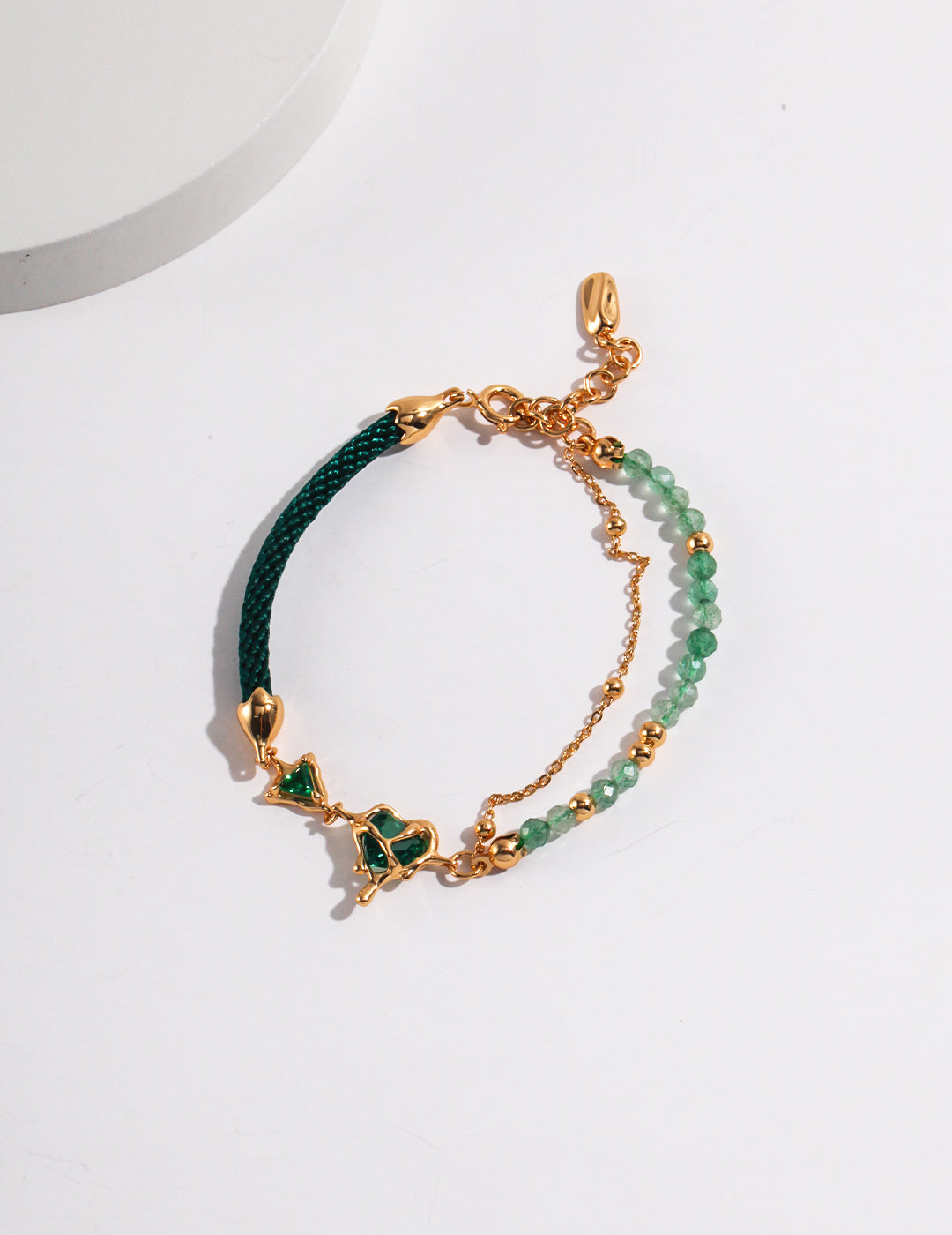 Dare To Sparkle - Avant-garde asymmetric split-design bracelet featuring faceted green strawberry quartz beads, fluid molten gold hearts, and a deep green woven silk cord