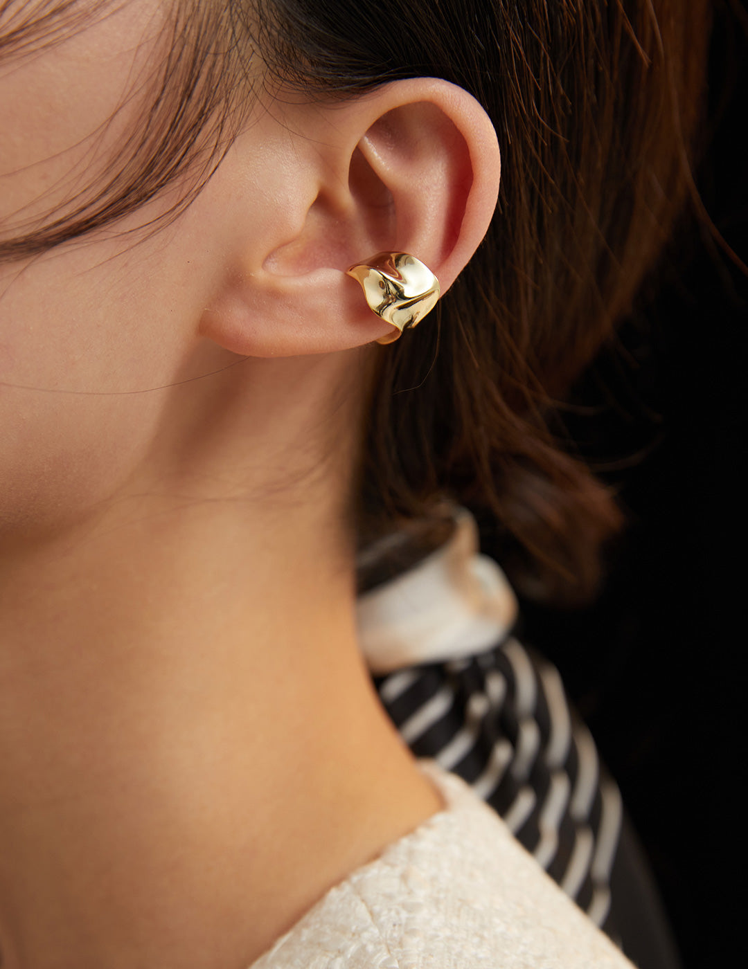 Dare To Sparkle - Avant-garde non-pierced ear cuff showing a wide high-polished fluid molten metal crumpled sculptural silhouette in 18k gold plating