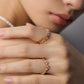 Close-up of a person's hand wearing two gold rings with a soft focus background