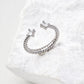 Contemporary minimalist open-band cuff ring in silver finishes featuring radiant prong-set cz gems flanking both open ends