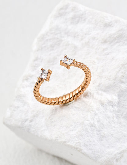 Contemporary minimalist open-band cuff ring in gold finishes featuring radiant prong-set cz gems flanking both open ends