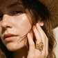 A model wearing a statement wide hollow open adjustable rings featuring artistic fluid cells and embedded cz crystals in gold